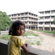 A young girl on an abandoned floor of a commercial block where her family has a makeshift home.